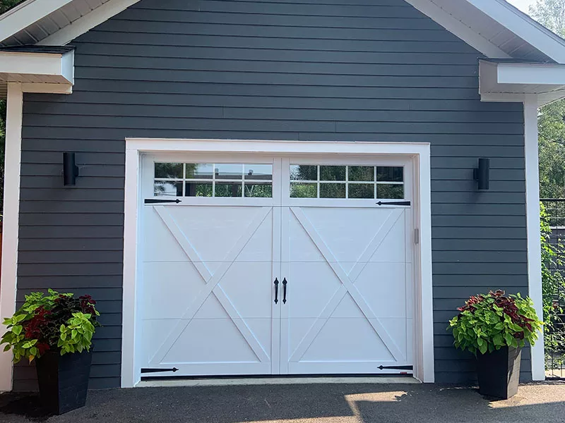 Garage au revêtement en vinyl bleu avec une porte de garage Eastman E-21 de couleur Blanc Glacier.